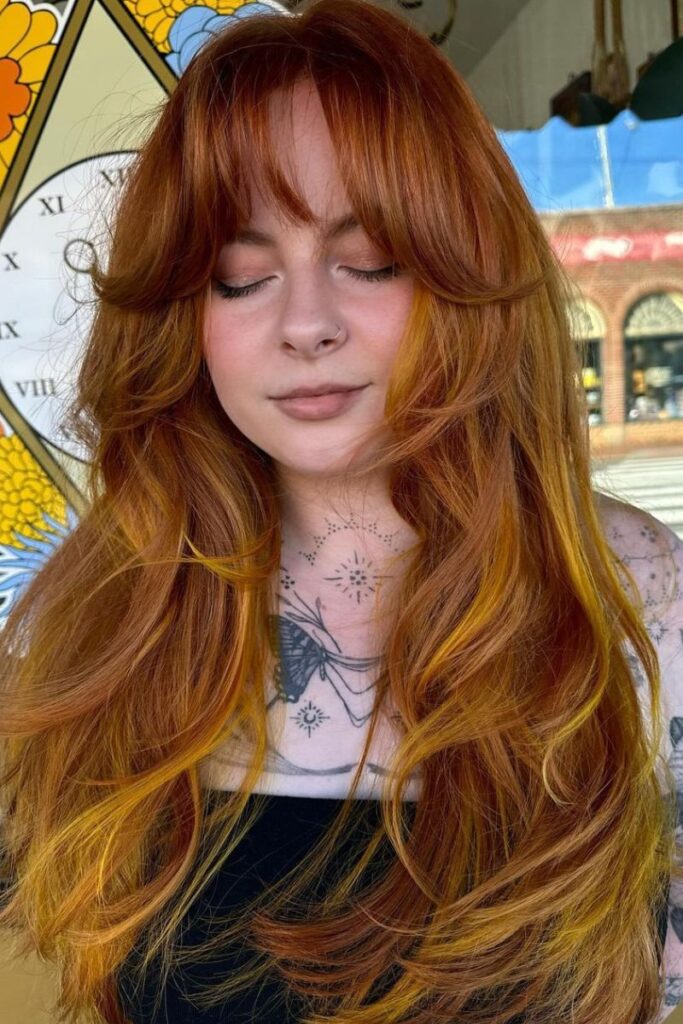 Long layered cut with curtain bangs and Smashed Pumpkin Spice color