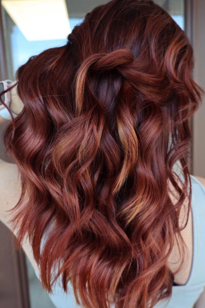 Wavy auburn hair with loose half-up twist highlights