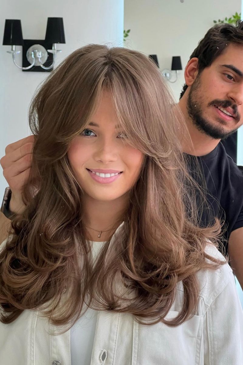 Long layered cut with curtain bangs.