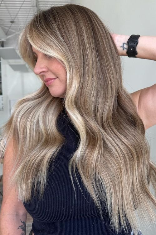 Old money blonde balayage with long waves and face-framing layers