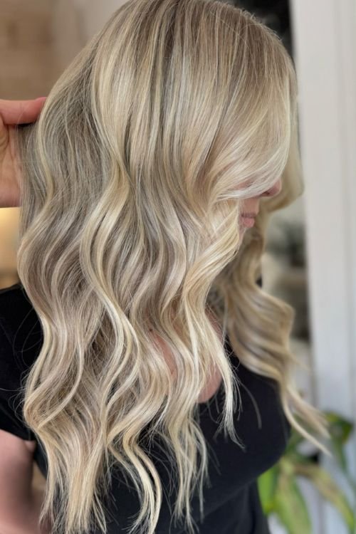 Old money blonde wavy cut with soft layers and side-swept bangs