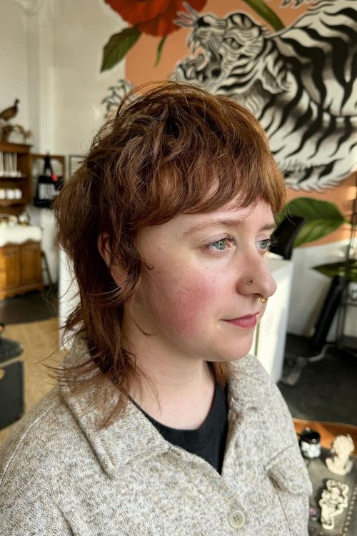 Soft mullet with shaggy layers choppy bangs and subtle highlights