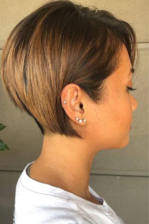 Undercut bob with side-swept bangs soft highlights light brown