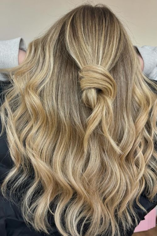 Wavy blonde with half-up knot and soft highlights