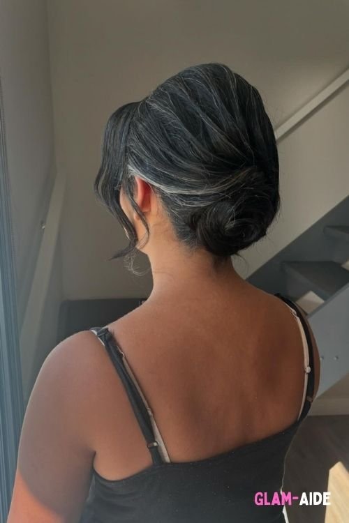 Sleek low twisted bun with loose face-framing strands