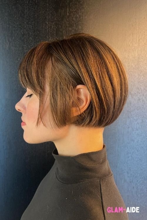 Sleek tapered razor cut bob with side-swept bangs